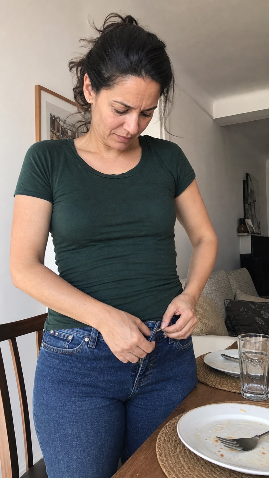 Mujer aflojándose el botón del pantalón después de comer